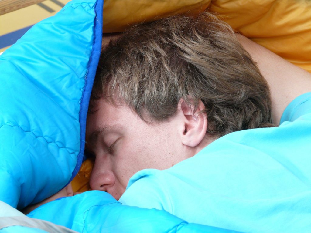 Schlafender Mann, fast komplett eingehüllt in seiner Decke.