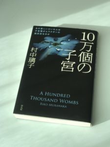 Buchcover, hauptsächlich schwarz, mit vielen japanischen Zeichen und einem englischen Titel: "A Hundred Thousand Wombs"