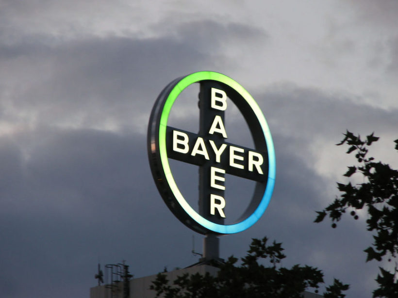 Das BAYER-Logo unter dem Abendhimmel