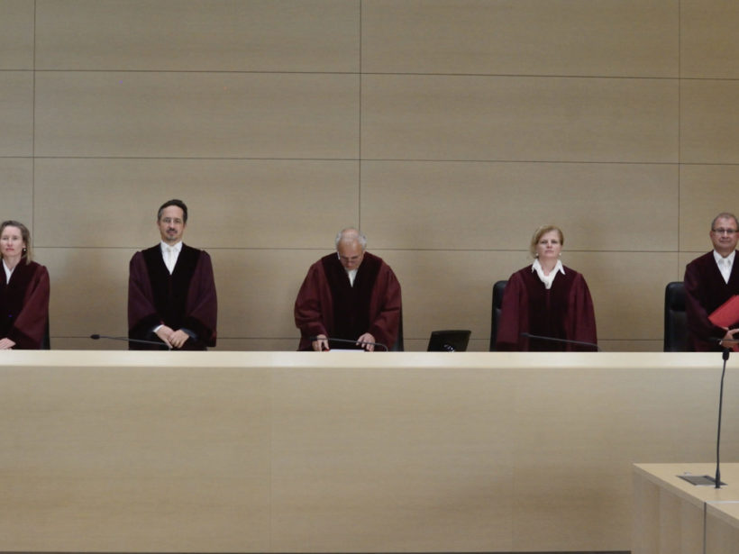 Richter und Richterinnen im Bundesgerichtshof, stehend hinter einem langen Pult.