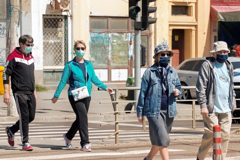 Mehrere Menschen mit Maske auf einer Straße