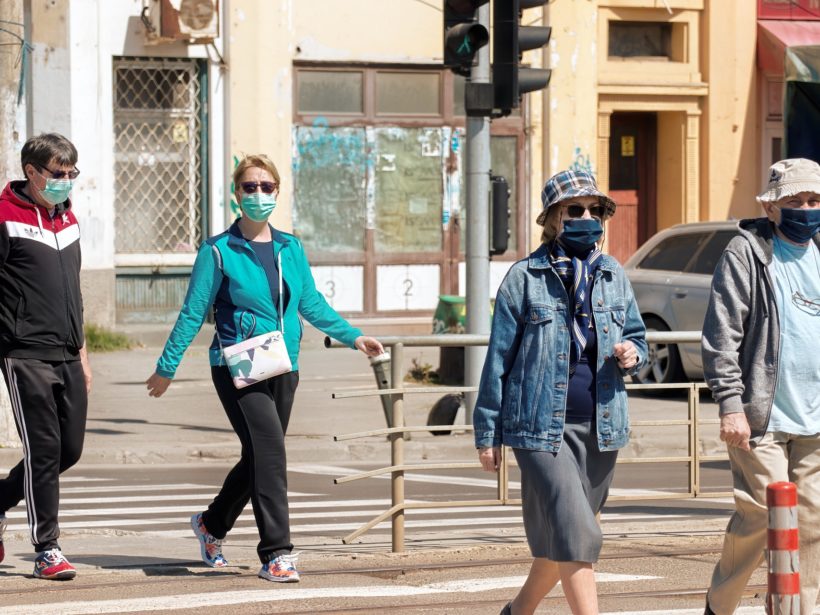 Mehrere Menschen mit Maske auf einer Straße