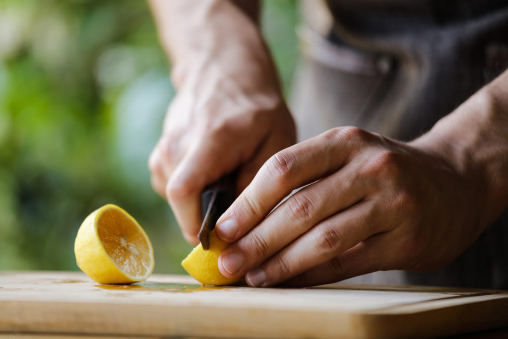 Ein Mann schneidet eine Zitrone