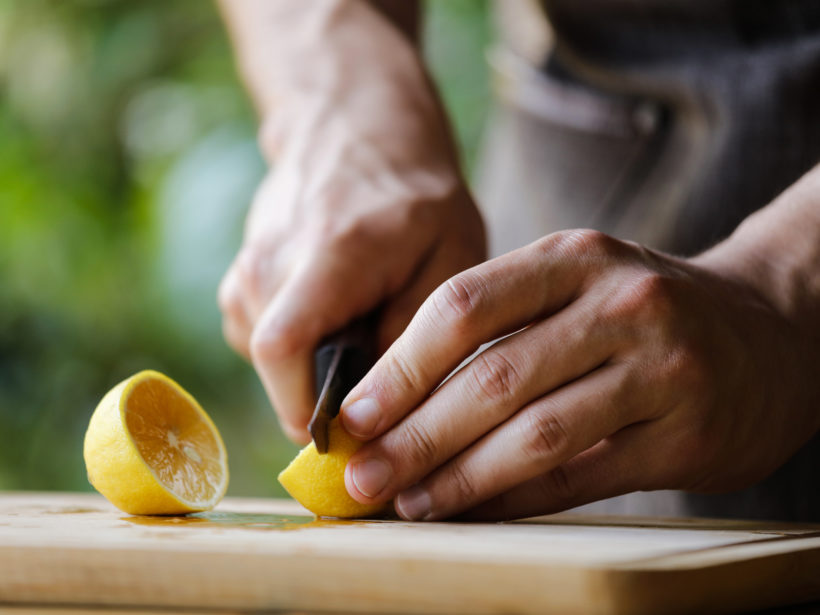 Ein Mann schneidet eine Zitrone