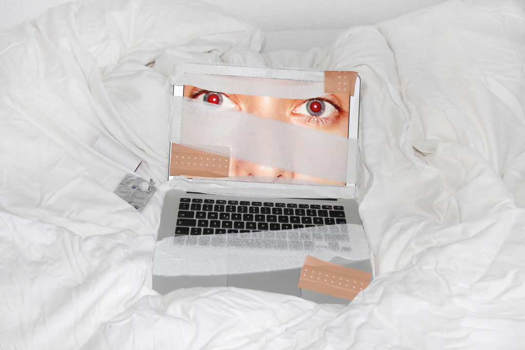 Laptop mit Gesicht und Verbandsmaterial