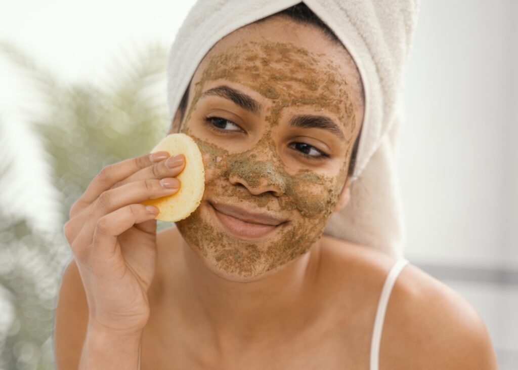 Junge Frau mit einer granulären Paste im Gesicht.